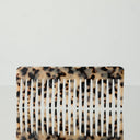 A tortoiseshell hair comb with vertical teeth, featuring a beige and black mottled pattern, shown against a plain white background.